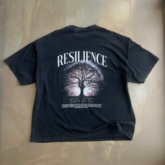 Vintage Black t-shirt with 'Resilience' graphic and text on a concrete surface