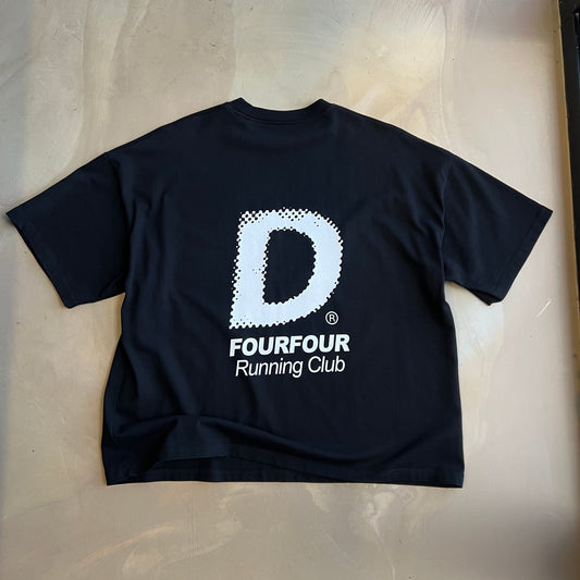 Black short sleeve t-shirt with a white logo on a light concrete surface