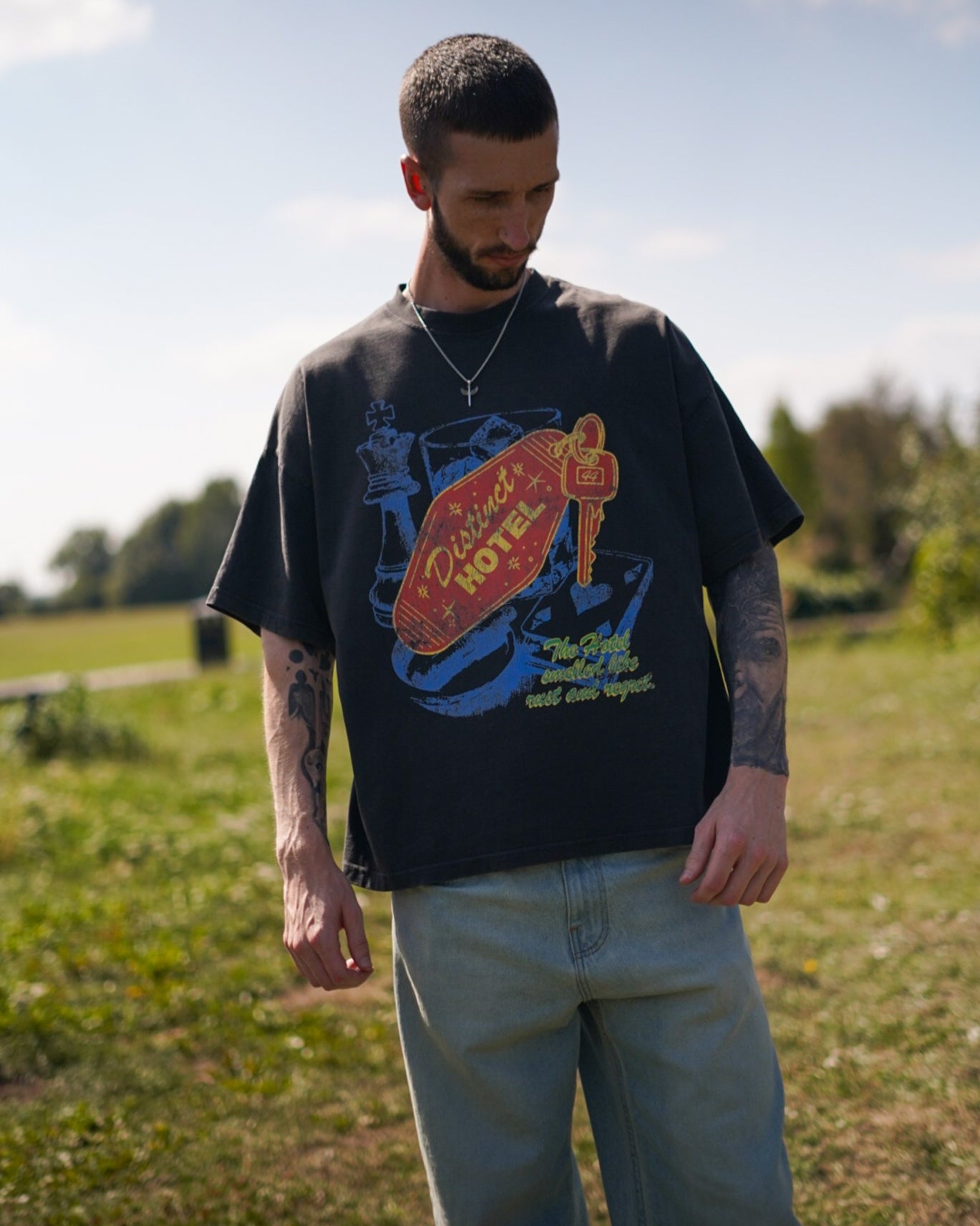 Man wearing a graphic t-shirt outdoors on a sunny day