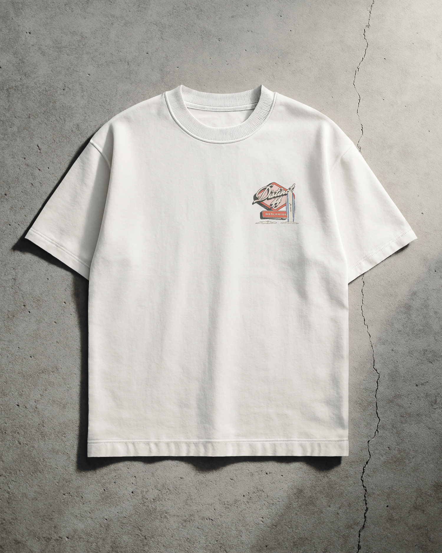 White t-shirt with a small graphic on a gray concrete surface