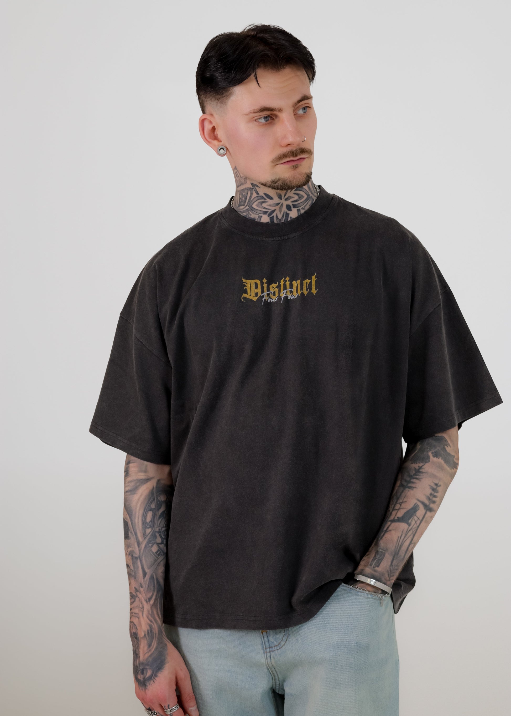 Man wearing a vintage black oversized t-shirt with visible branding against a plain background