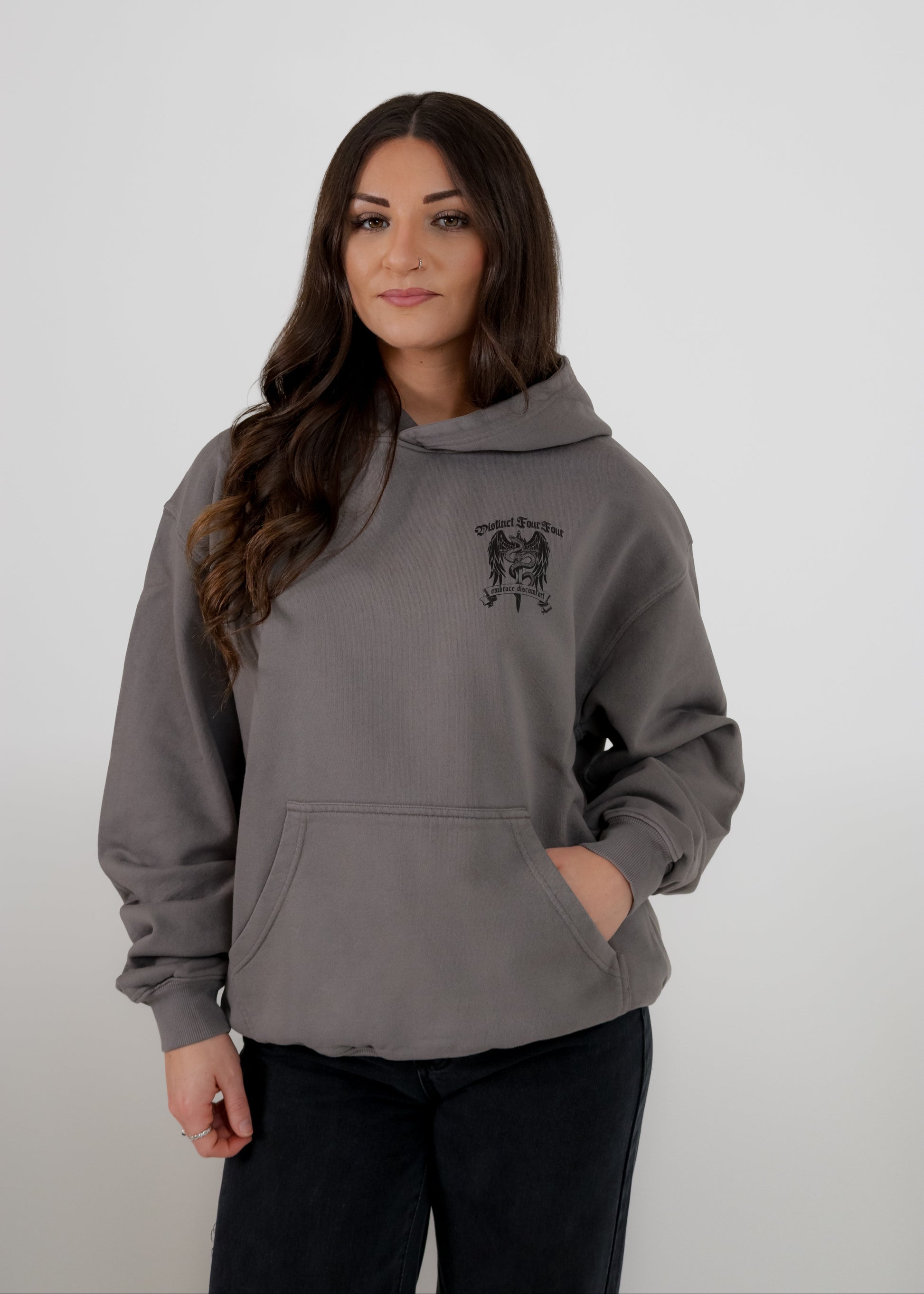 Woman wearing a gray hoodie with a logo on a white background