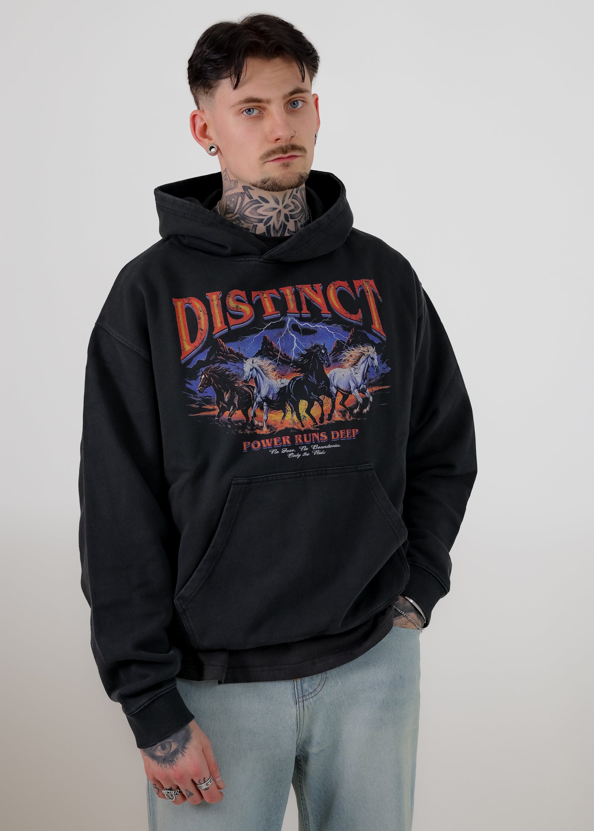 Person wearing a black hoodie with 'Distinct' graphic design on a plain background