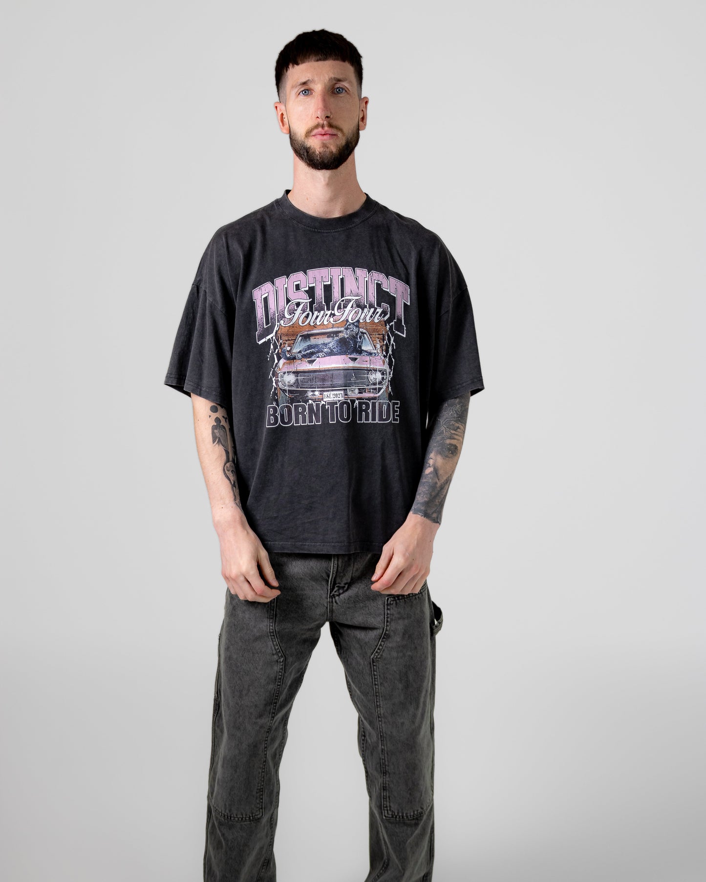 Man wearing a black t-shirt with graphic design and text, standing against a plain background
