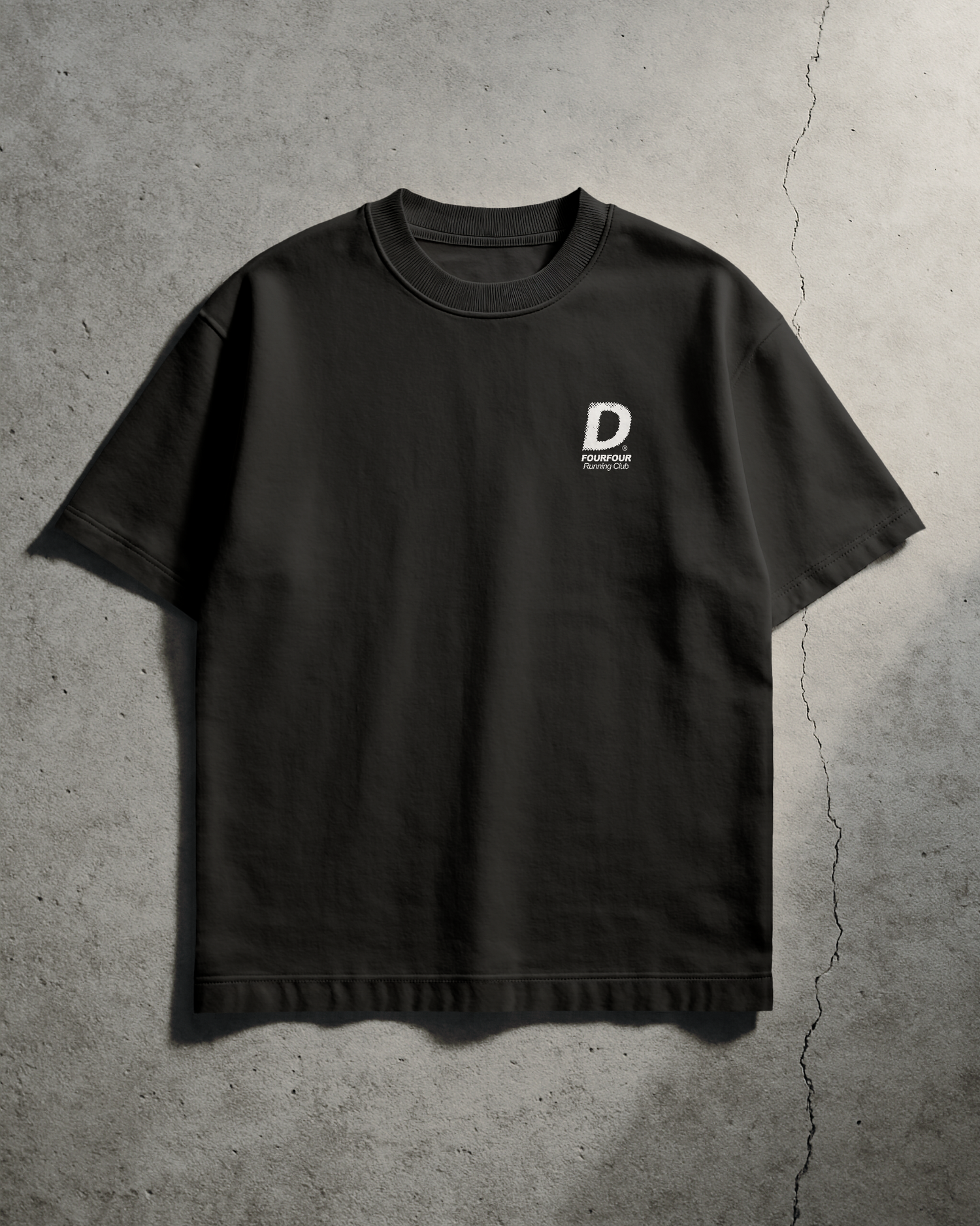 Black t-shirt with a logo on a concrete floor