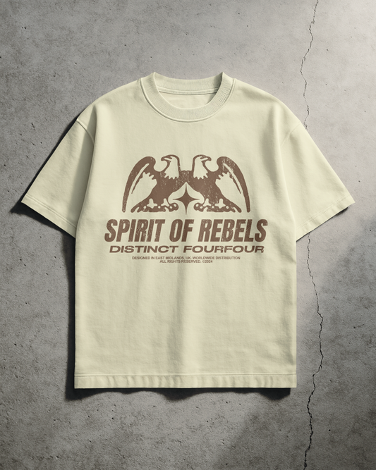 Cream t-shirt with brown graphic and text on a gray concrete background