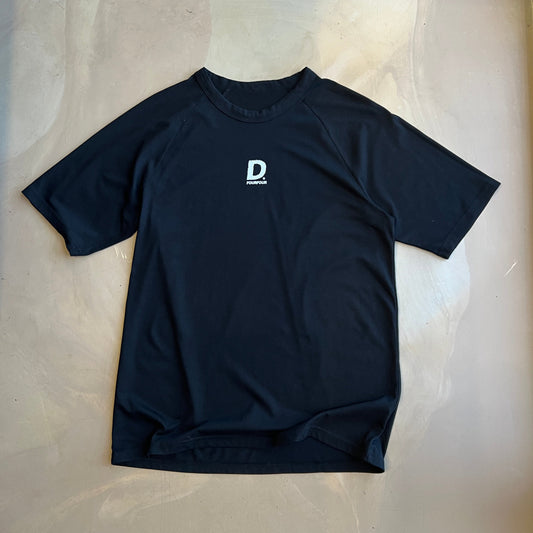 Black short sleeve shirt with a logo on a light gray surface