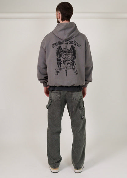 man wearing a grey hoodie with a graphic design on the back against a white background