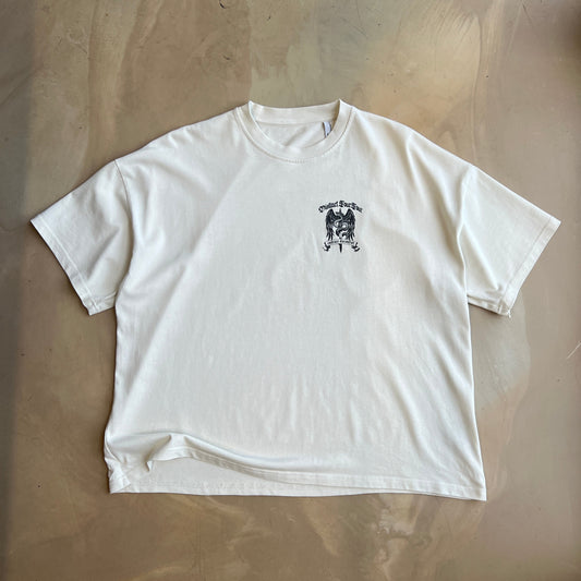 Vintage White t-shirt with a small black graphic on a concrete surface