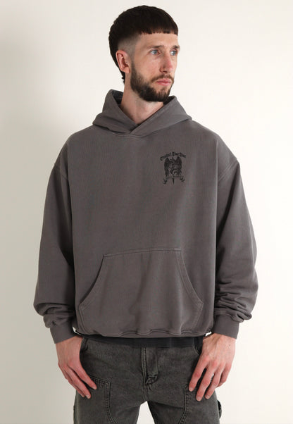 Man wearing a gray hoodie with a logo on a plain background