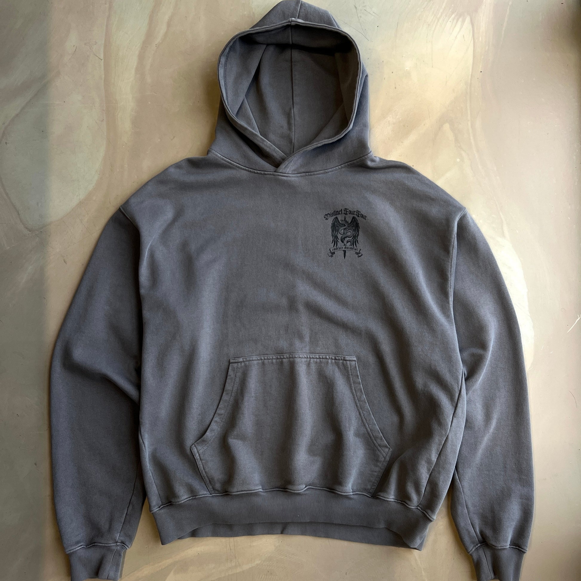 Pigment Grey hoodie with a small logo on the chest against a neutral background
