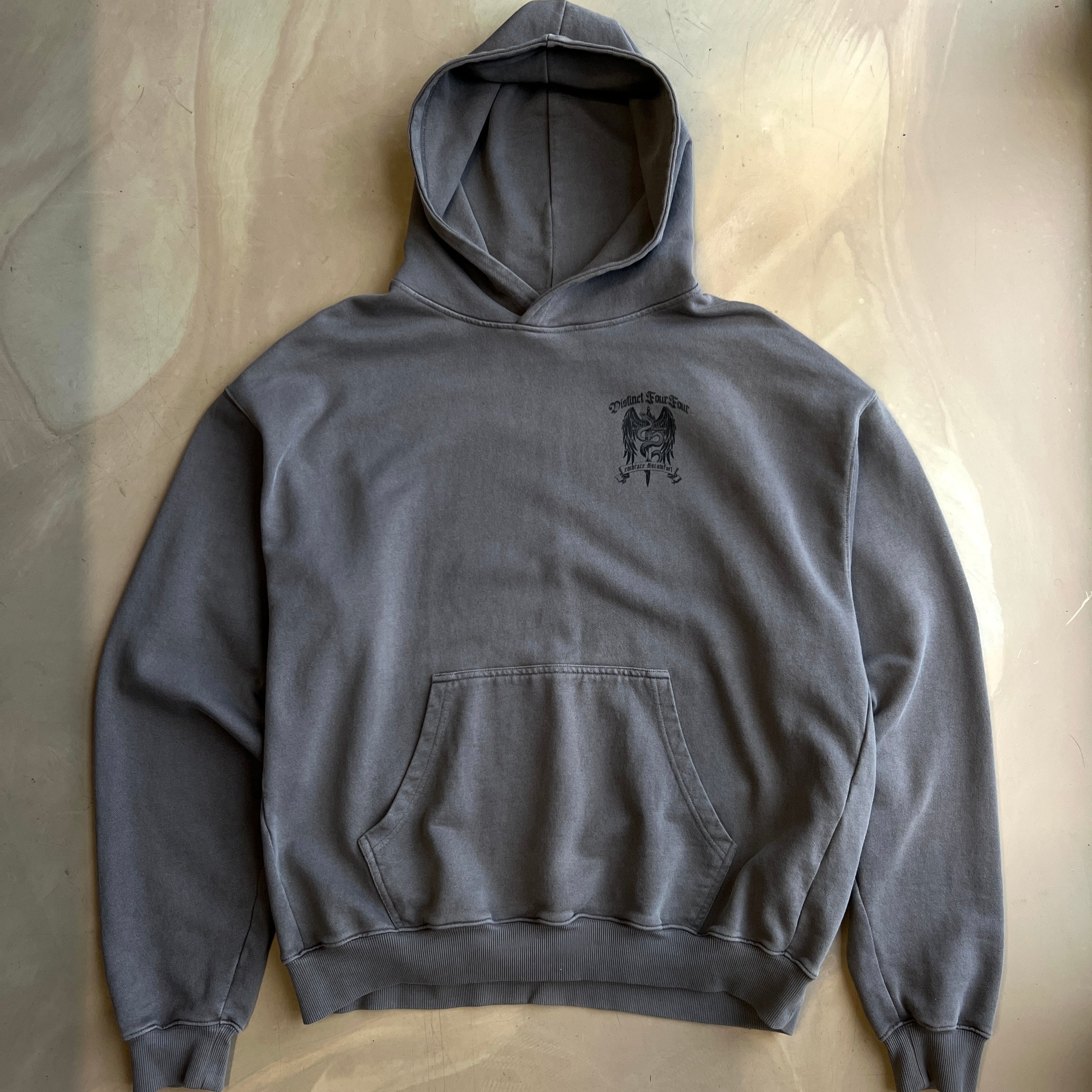 Pigment Grey hoodie with a small logo on the chest against a neutral background