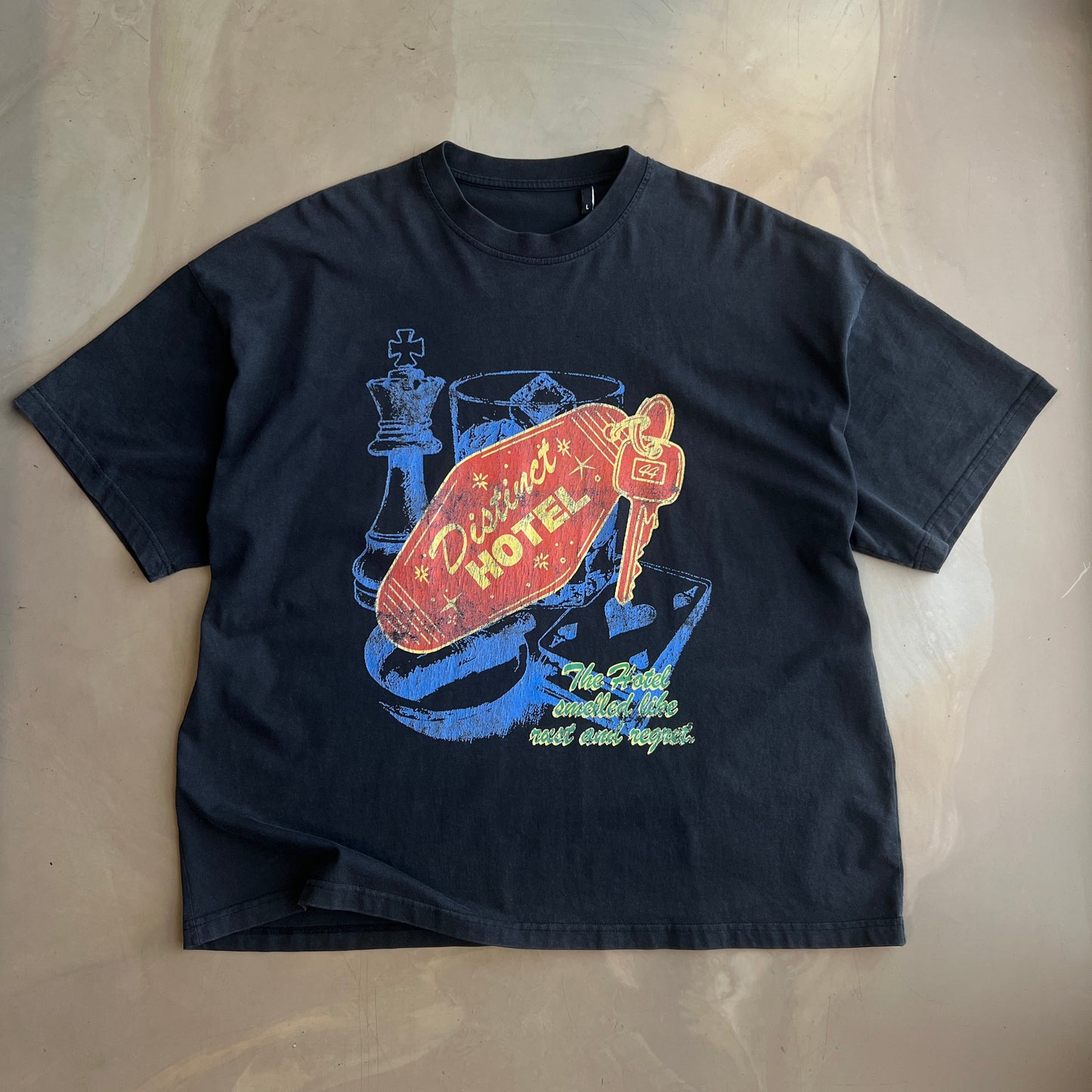 Vintage Black t-shirt with colorful graphic design on a concrete surface