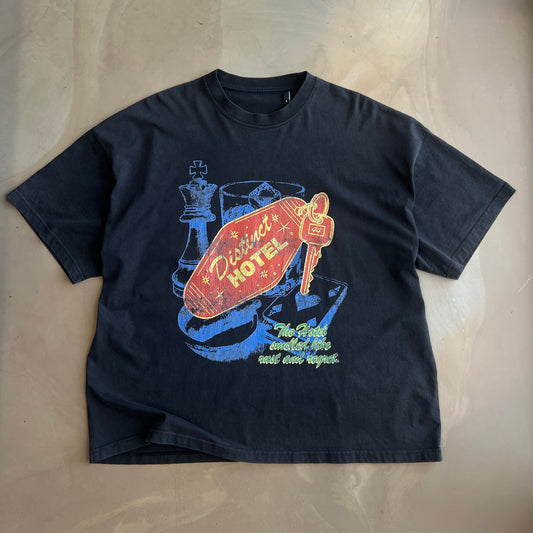 Vintage Black t-shirt with colorful graphic design on a concrete surface