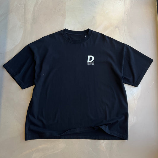 Black t-shirt with a white logo on a light concrete surface