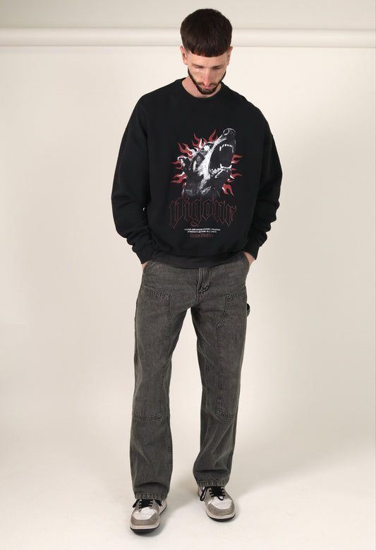 Person wearing a  vintage black sweatshirt with a graphic design and grey jeans on a white background